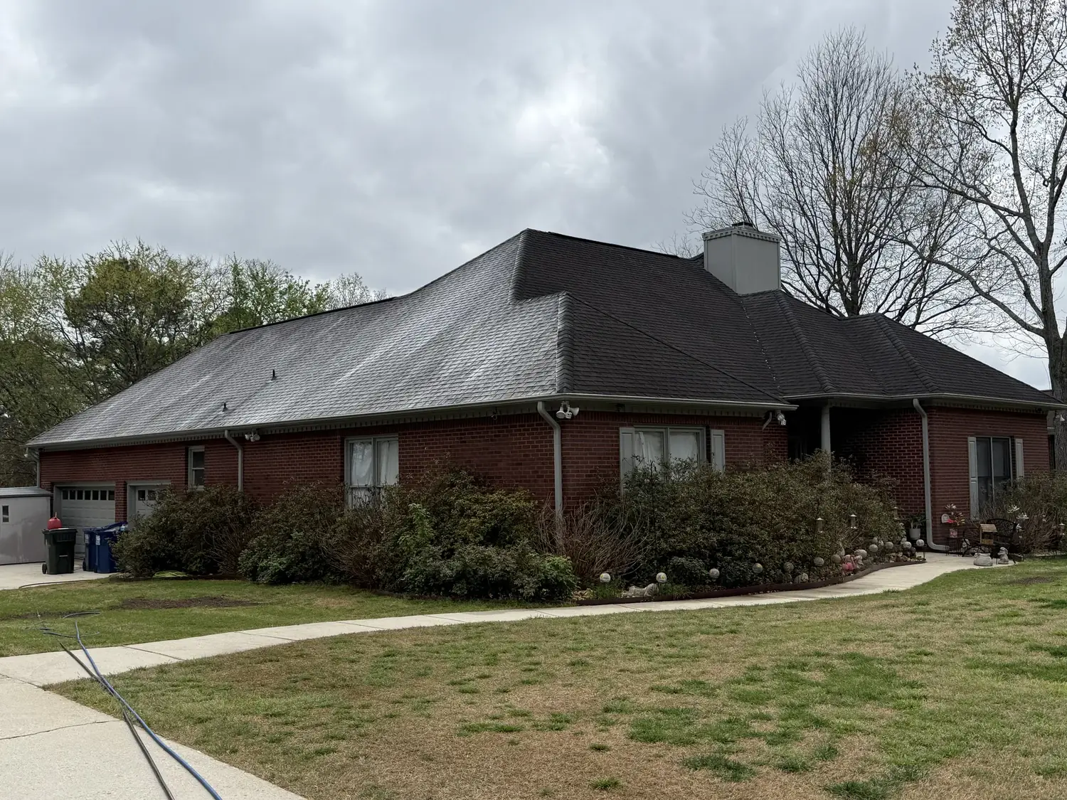 Roof soft wash in progress on an asphalt shingle roof in Huntsville AL